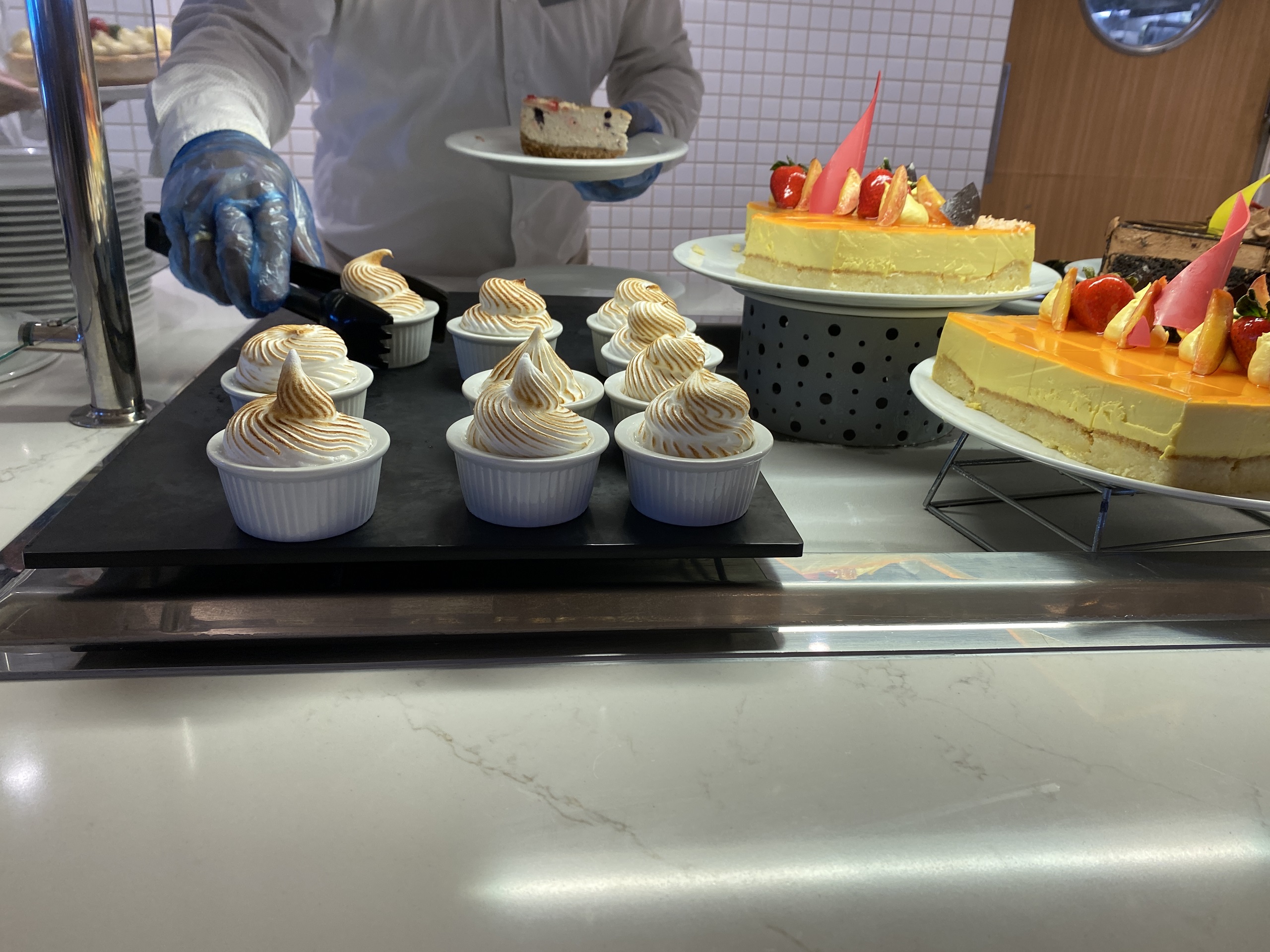 A crewmember serves a slice of cake at the dessert station on Celebrity Millennium.