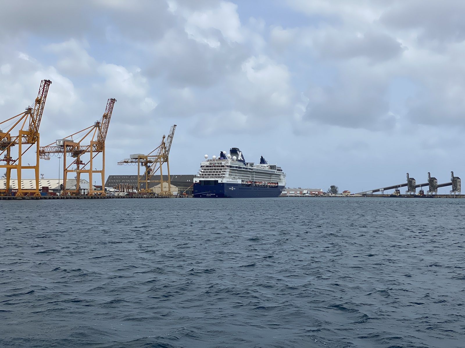 A rear shot of Celebrity Millennium docked in Barbados next to shipping cranes