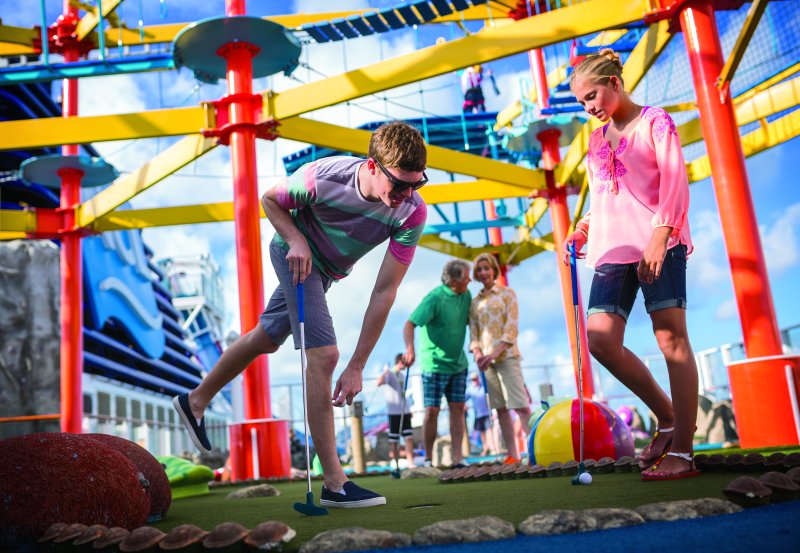 A family plays mini-golf while the ropes course looms above on NCL's Norwegian Breakaway (source: NCL)