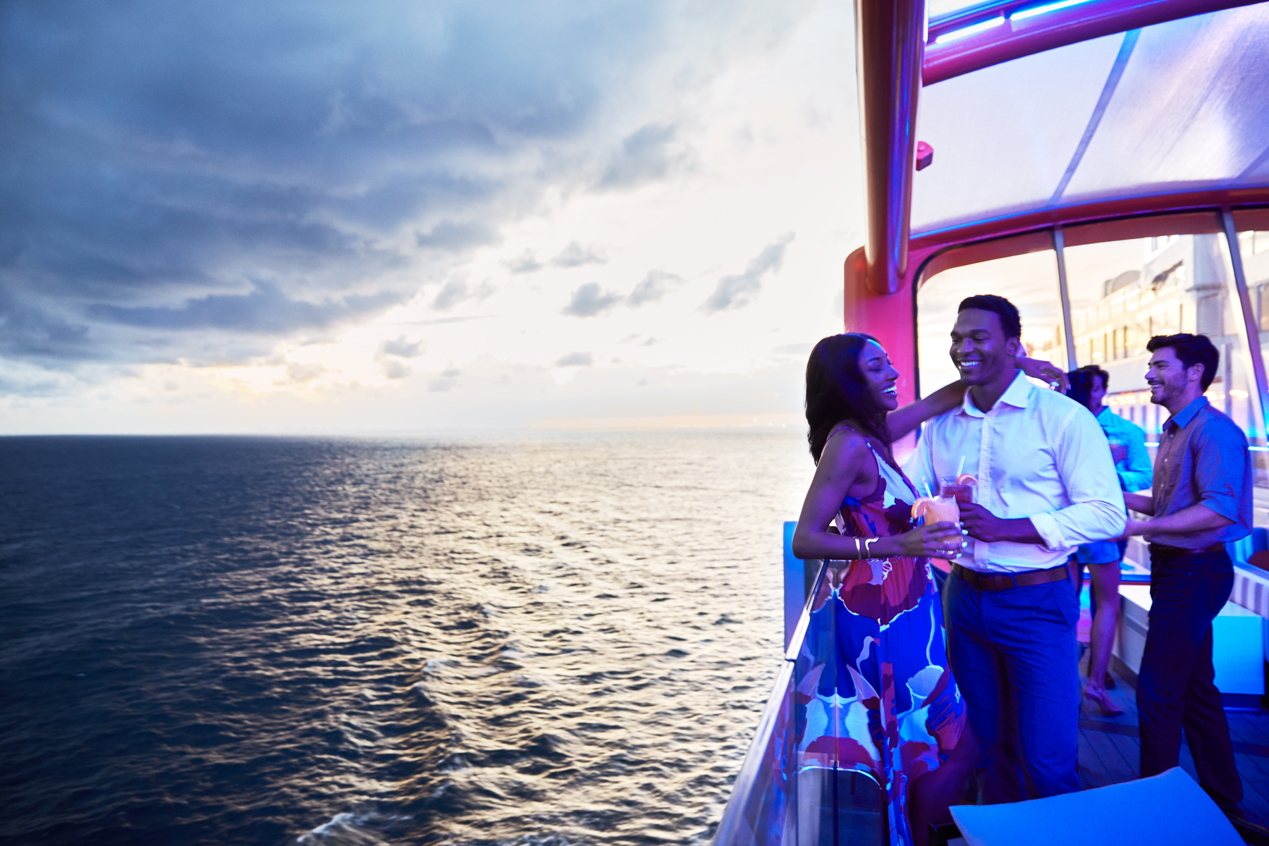 A couple on Celebrity Edge's Magic Carpet at sunset (source: Celebrity Cruises)