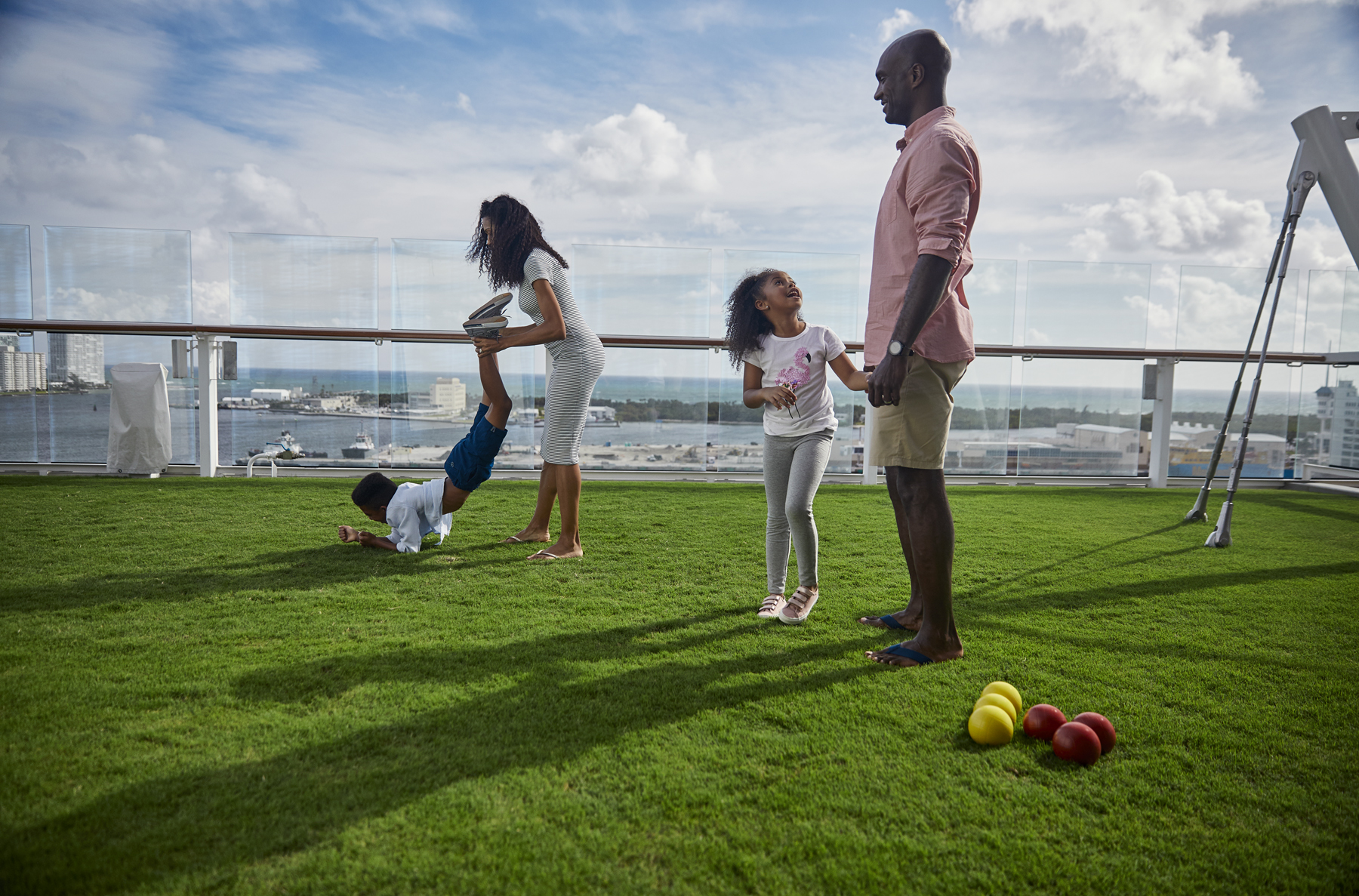A family plays bocce on the grass at the Lawn Club on a Celebrity cruise ship (source: Celebrity Cruises)