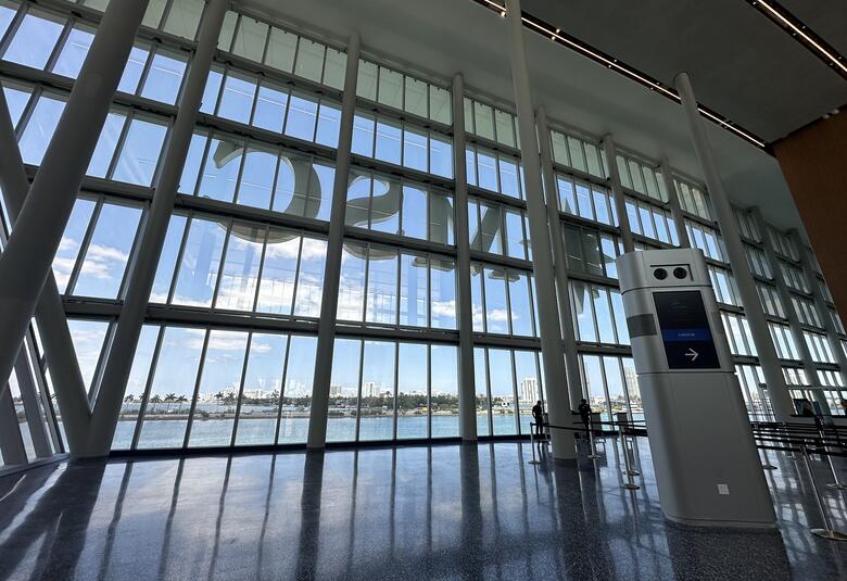 Floor-to-ceiling windows and a check-in kiosk at a cruise ship terminal
