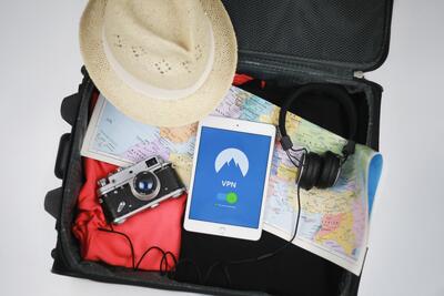 Suitcase with camera, clothes, hat, map, headphones and tablet (source: Madskip, Pixabay)