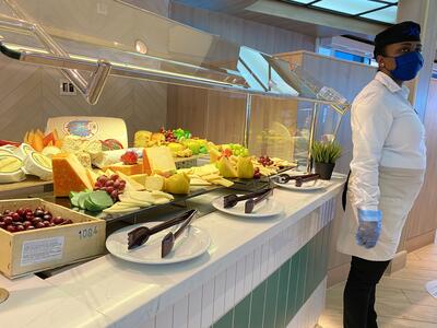 Cruise crew member waiting to serve food at the buffet