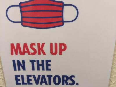 Mask up in the elevators sign
