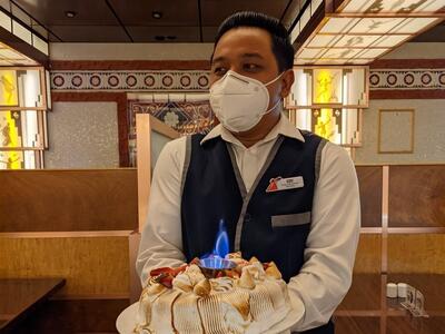 waiter holding Baked Alaska on Carnival Pride