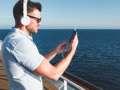 Man using his phone on a cruise ship