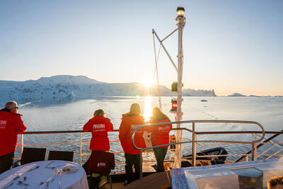 four people watching the sunset in Antarctica