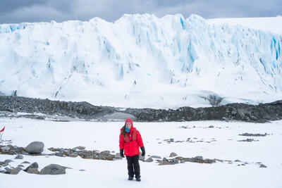 girl standing in front of a glacier