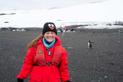 girl smiling with a penguin in the background