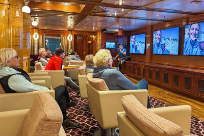 Expedition guide giving a lecture in the Oceanus Lounge