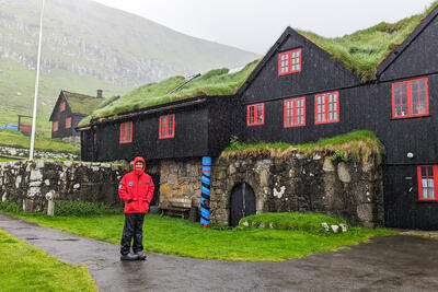 man standing in front of a house in the Faroe Islands