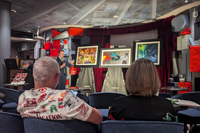 Auctioneer showing artwork at an art auction