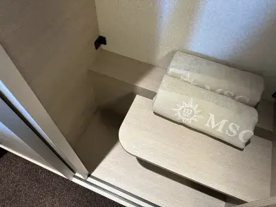 A cruise ship cabin closet with space cut out for long clothes to hang