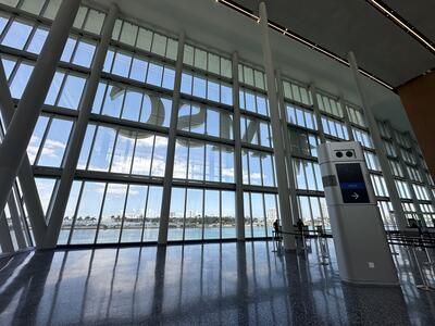 Floor-to-ceiling windows and a check-in kiosk at a cruise ship terminal