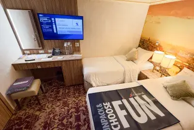 Twin beds in Carnival Firenze interior cruise cabin