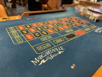 A casino gaming table with red and black numbered squares and the words "Margaritaville at Sea"