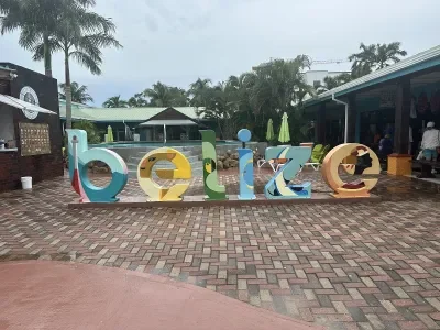 A colorful sculpture spelling out "Belize" on a brick sidewalk in Belize City