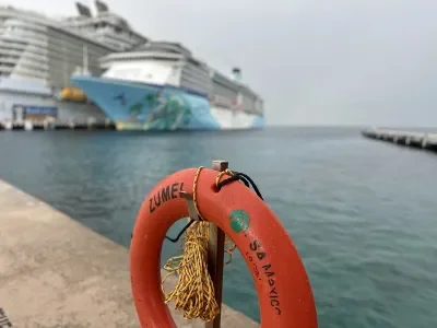 A life ring on a pier with two cruise ships in the background