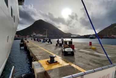 Crew members from the Carnival Pride are shown debarking the vessel to join repatriation flights returning them to their home countries.