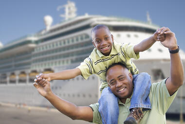 Stock image of father and son in front of a cruise ship