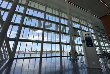 Floor-to-ceiling windows and a check-in kiosk at a cruise ship terminal