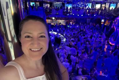 Selfie of a woman with a glow party behind her in a cruise ship atrium